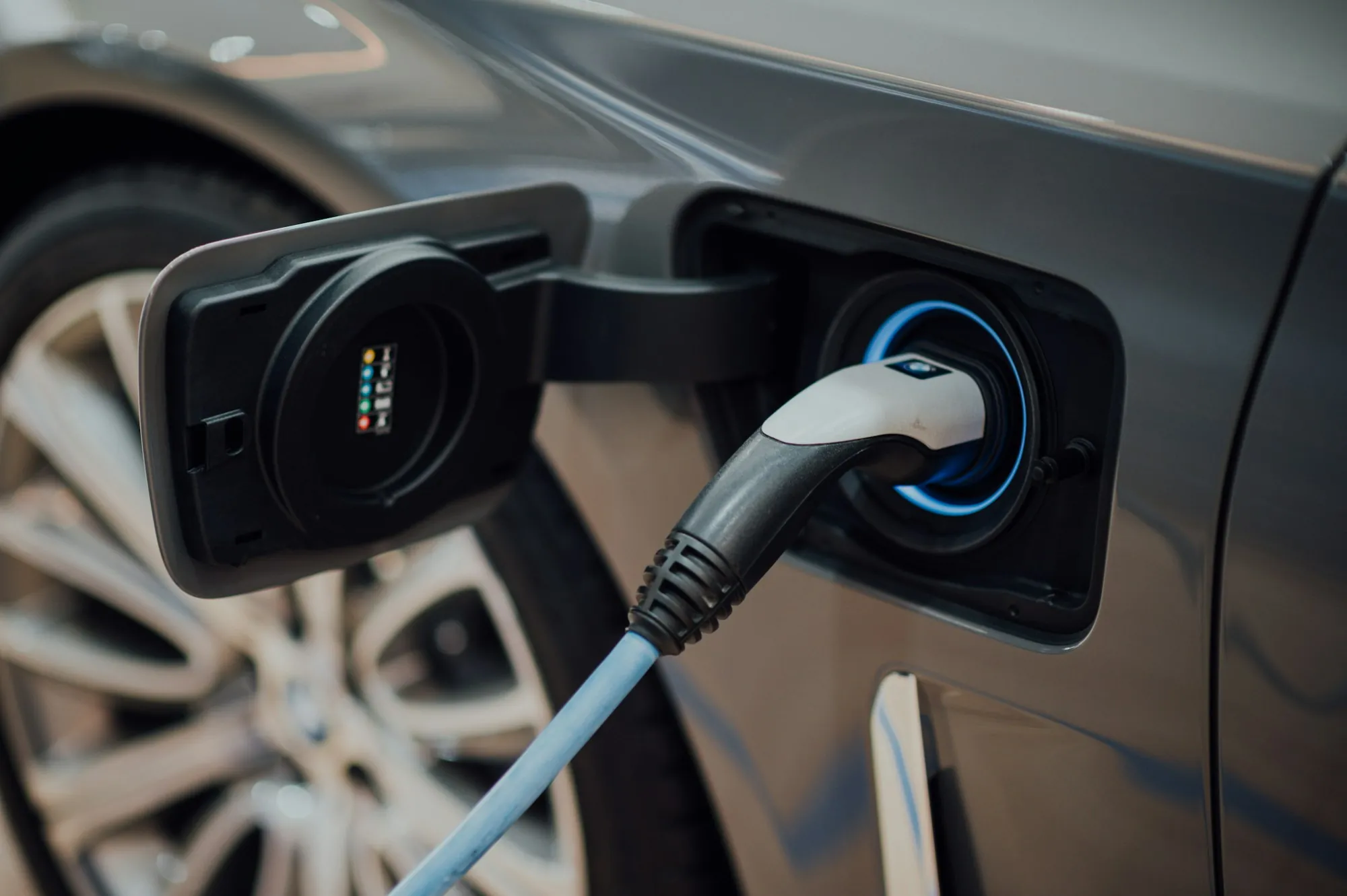 A charging cable plugged into the charge port of an electric car