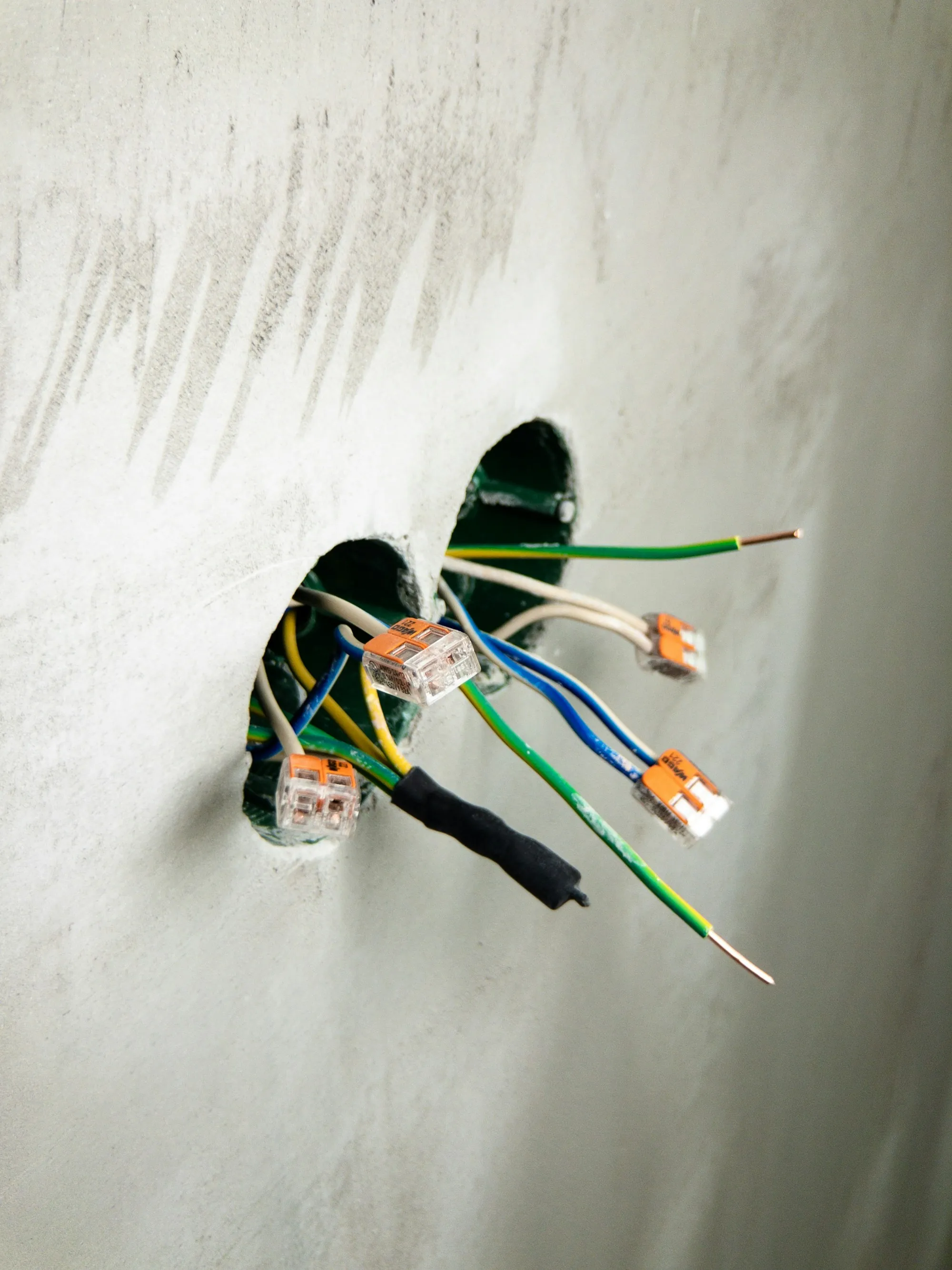 Electrical cables emerging from an opening in a wall